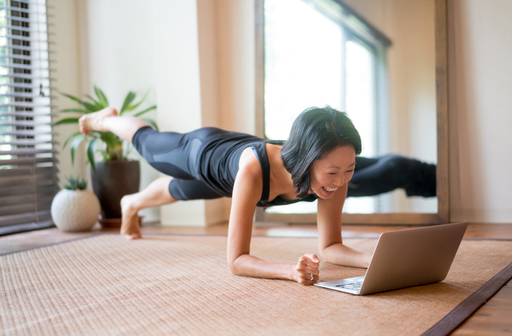 Asian woman exercising at home using Virtual YMCA