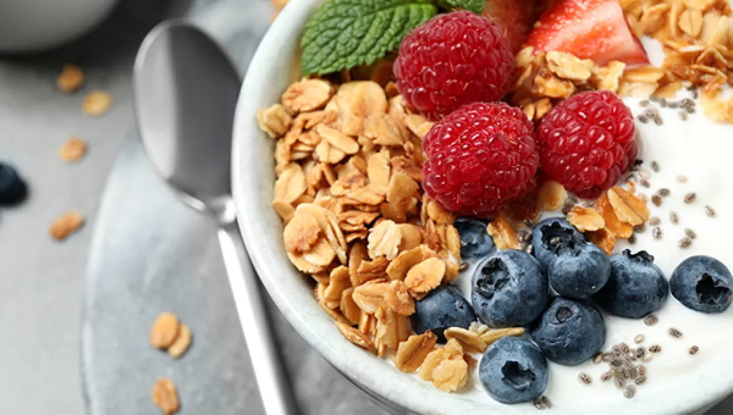 A healthy bowl of granola, strawberries, blueberries and yogurt