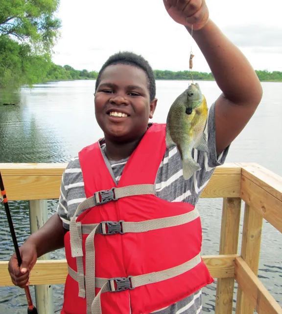 Teen boy showing fish he caught