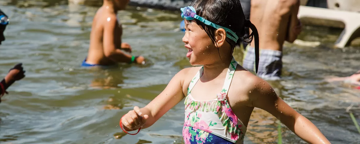 Girl playing in lake with other kids