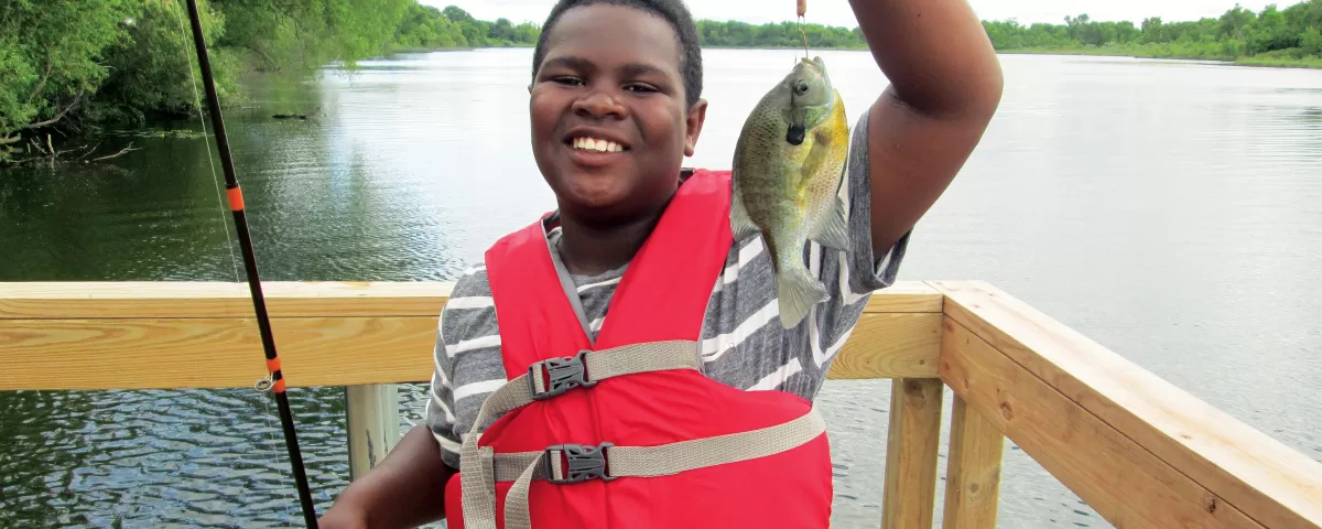 Teen boy showing fish he caught