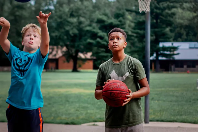 Two teens playing basketball