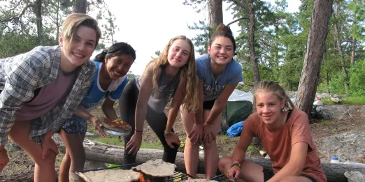 Teenagers cooking outdoors